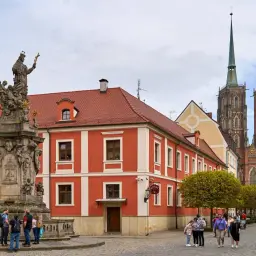 Kolumna Zygmunta i katedra na Ostrowie Tumskim we Wrocławiu. Grupa turystów podziwia zabytki.
